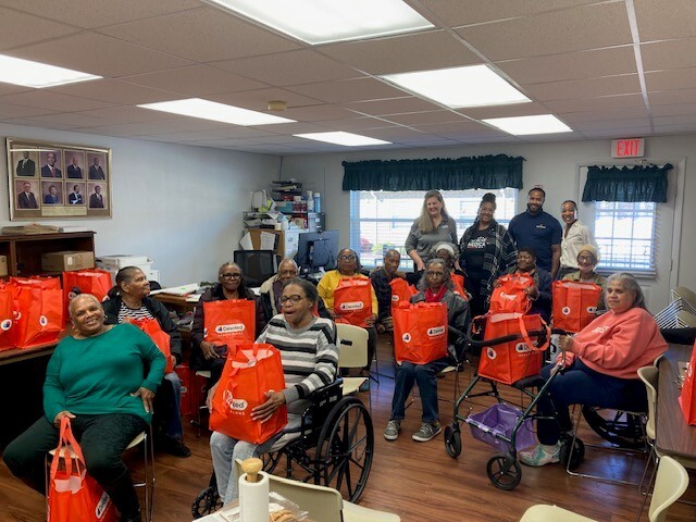 A room full of people holding goody bags.