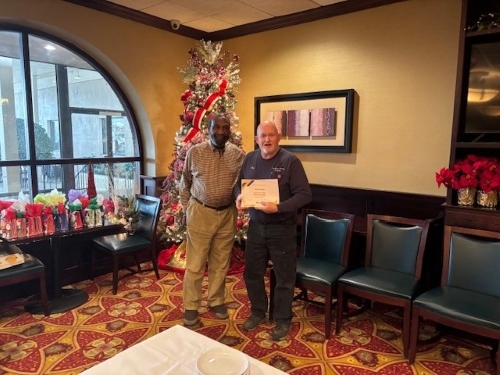 A man with Tim Smith receiving a 15 years of service award.