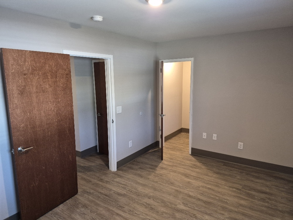A view from inside a bedroom looking into the hall, and closet.
