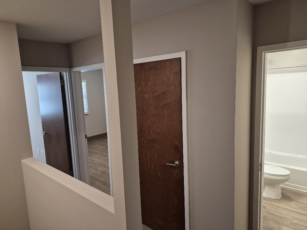 A view from the hall looking in two bedrooms, a closet and the bathroom.