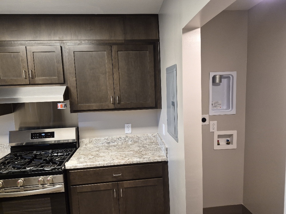 A partial view of the kitchen on the left, with a spot for a stackable washer and dryer on the right.