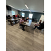  People sit at a couple different tables filling out paperwork. 