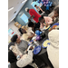  A group of people sit around tables eating and talking. 